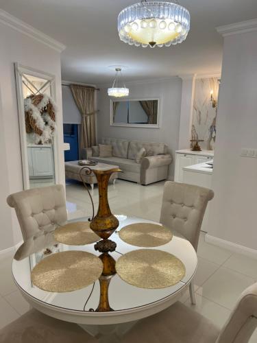 ein Wohnzimmer mit einem Tisch und 2 Stühlen in der Unterkunft Apartament Parys Gold in Malbork