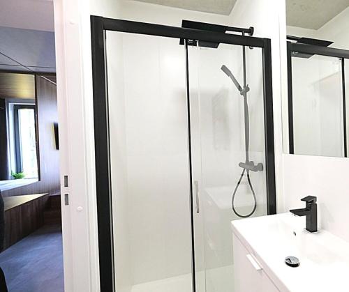W łazience znajduje się szklana kabina prysznicowa i umywalka. w obiekcie Legnicka Business Apartments we Wrocławiu