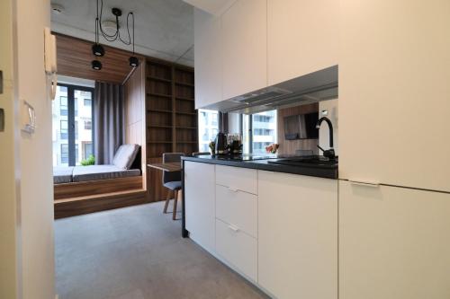 a kitchen with white cabinets and a counter top at Legnicka Business Apartments in Wrocław