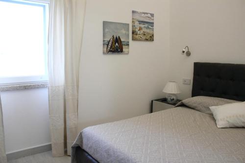 1 dormitorio con cama y ventana en Case al mare di Cala Saccaia, en Pittulongu 