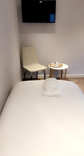 a bedroom with a bed and a table and a tv at The Caledonian in Portree