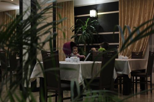 two children sitting at a table in a restaurant at Lisova Pisnia Resort Hotel in Truskavets