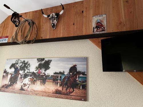a picture hanging on a wall with a picture of a cow at Hotel Le Ranch in Brûlon