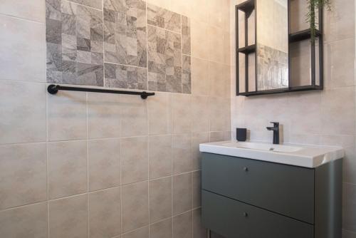 La salle de bains est pourvue d'un lavabo et d'un miroir. dans l'établissement NEW ! Cozy Casa, à Oranjestad