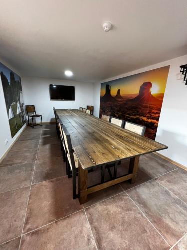 a dining room with a wooden table and chairs at Hotel Le Ranch in Brûlon