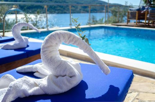 two white towels on a table next to a swimming pool at Villa Paradise in Vela Luka