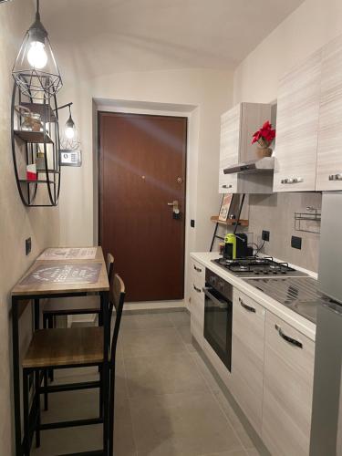 a small kitchen with a table and a door at HappyHome Bilocale centro storico Rivarolo Canavese in Rivarolo Canavese