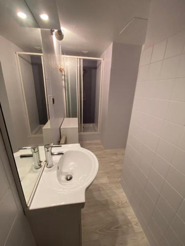 a white bathroom with a sink and a mirror at Boost Your Immo Ramond Barèges PM26 in Barèges