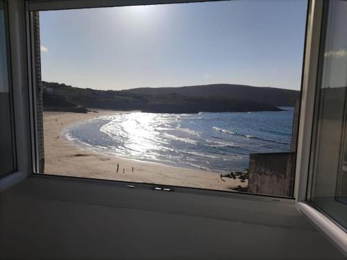 a view of a beach from a window at Casa Consuelo Malpica in Malpica