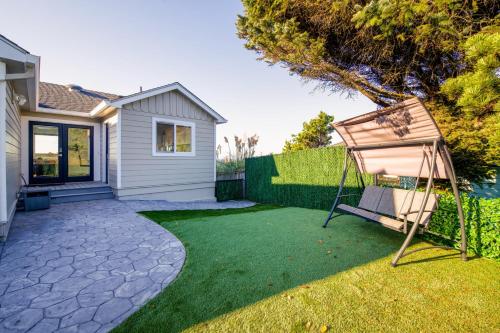 a yard with a swing in the grass at Loki's Kingdom in Rockaway Beach