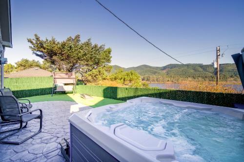 a hot tub sitting on a patio with a chair at Loki's Kingdom in Rockaway Beach