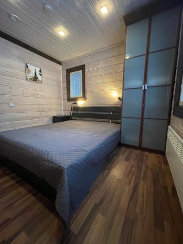 a bedroom with a large bed in a wooden room at Levi Unelma Villa in Levi