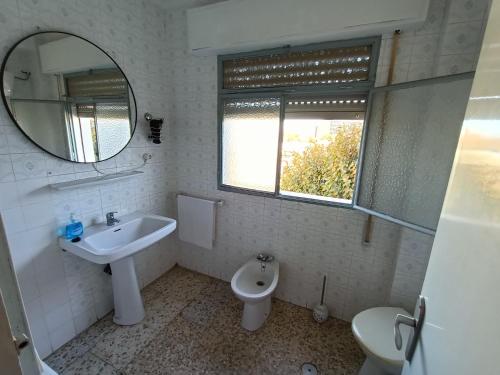 a bathroom with a sink and a toilet and a mirror at Apartamento 3 dormitorios con aire acondicionado in Granada