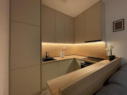a kitchen with white cabinets and a sink at Hills Apartments in Podgorica