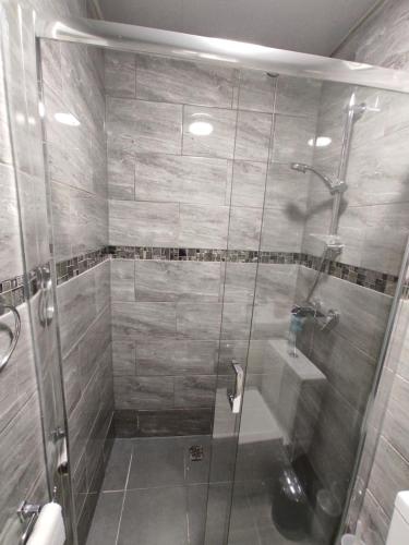 a shower with a glass door in a bathroom at Private bedroom near NEC, Birmingham airport,city centre in Birmingham