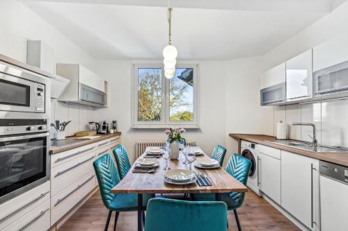 een keuken met een houten tafel en blauwe stoelen bij Mark 51-7 - Workplace - Netflix - Washer Dryer - Modern Design in Bochum