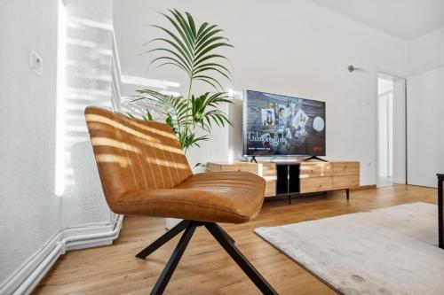 a brown chair in a living room with a tv at Mark 51-7 - Workplace - Netflix - Washer Dryer - Modern Design in Bochum