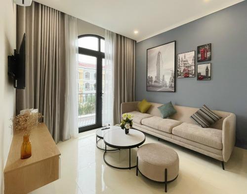 ein Wohnzimmer mit einem Sofa und einem Tisch in der Unterkunft Sel de Mer Apartment Grand World Phu Quoc in Phu Quoc