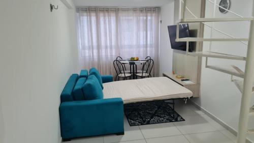 Habitación con silla azul y mesa. en ISRAEL FLAT DUPLEX C/ PISCINA, en João Pessoa