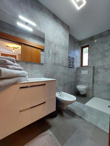 a bathroom with a sink and a tub and a toilet at Alpensafari Design Appartment in Bad Kleinkirchheim