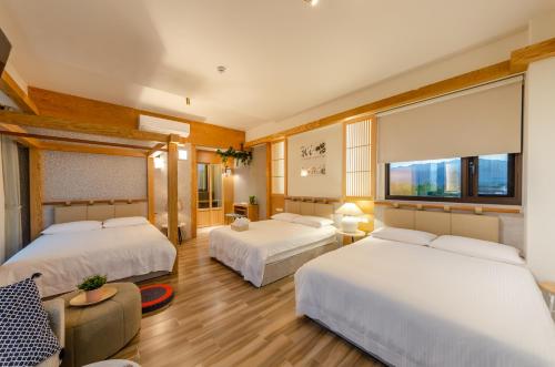 a hotel room with two beds and a window at Shanlight B&B in Yilan City