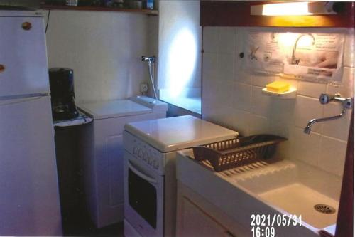 Il comprend une petite cuisine équipée d'une cuisinière et d'un évier. dans l'établissement Maison atypique du Cantal proche Lot et Corrèze, à Siran