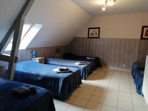 Cette chambre comprend 2 lits et une fenêtre. dans l'établissement Domaine de Meslay, chambres avec salle d'eau et wc, à Fyé