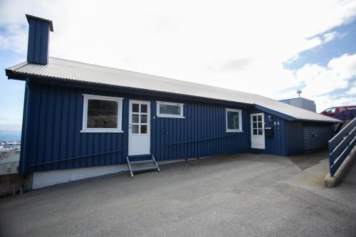 un edificio azul con un coche aparcado delante de él en Tórshavn Apartment - Great View, en Tórshavn