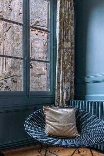 a pillow sitting on a bench in a room with a window at La Maison Pavie in Dinan
