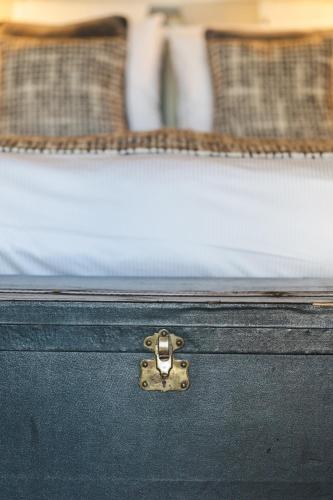 a black suitcase sitting on top of a bed at La Maison Pavie in Dinan
