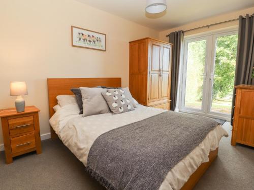 a bedroom with a large bed and a window at Hafan Fach in Mold