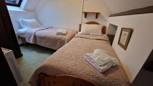 a small room with two beds with towels on them at Hayloft Cottage - Dog Friendly With Private Garden in Sidmouth