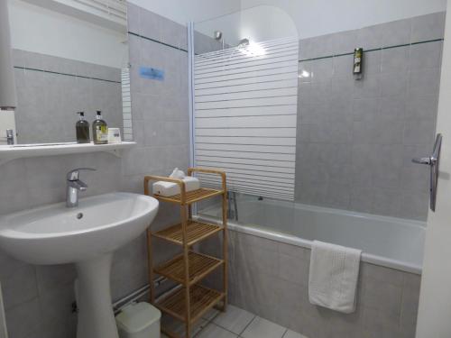 y baño con lavabo, aseo y bañera. en Hôtel Logis La Crémaillère, en Saint-Bonnet-en-Champsaur