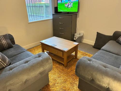 a living room with two couches and a coffee table at Cheerful newly refurbed 5 bed! in Derby