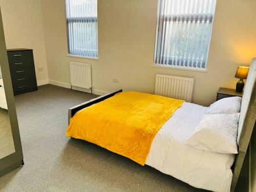 - une chambre avec un grand lit et une couverture jaune dans l'établissement Cheerful newly refurbed 5 bed!, à Derby