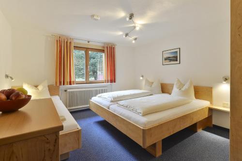 sypialnia z łóżkiem, biurkiem i oknem w obiekcie Haus Anna Apartments w mieście Langen am Arlberg