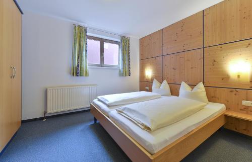 a bedroom with a large bed with a wooden headboard at Haus Anna Apartments in Langen am Arlberg