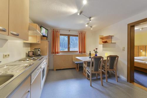 a kitchen and dining room with a table and chairs at Haus Anna Apartments in Langen am Arlberg