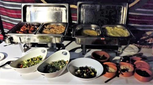a table with dishes of food and a stove at Desert Moments Glamping - full privacy in Muntarib