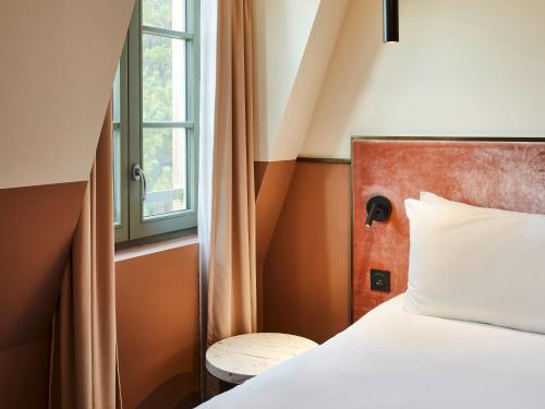 1 dormitorio con cama y ventana en TRIBE Hôtel Le Touquet en Le Touquet-Paris-Plage