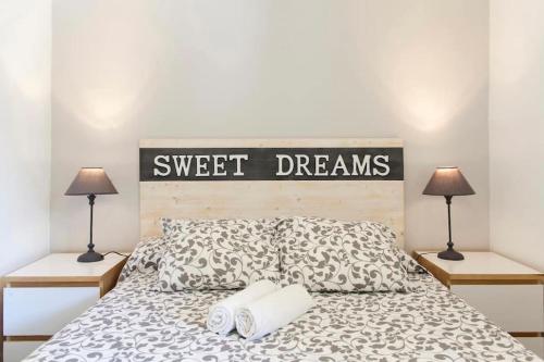 ein Schlafzimmer mit einem Bett mit einem Schild, das süße Träume liest in der Unterkunft Cute tiny flat near the beach and city center in Tossa de Mar