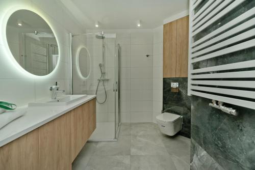 a bathroom with a sink and a shower and a toilet at BlueApart Apartamenty Na Klifie in Władysławowo