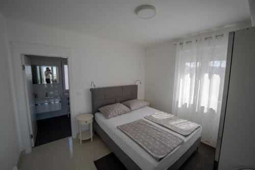Schlafzimmer mit einem Bett, einem Waschbecken und einem Spiegel in der Unterkunft Apartments Kovacev in Zadar