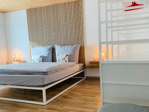 sypialnia z łóżkiem i drewnianą podłogą w obiekcie Dorf(er)leben Ferienwohnung im Kleinwalsertal w mieście Mittelberg
