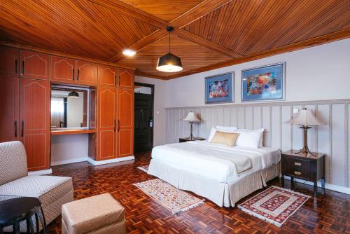 a bedroom with a white bed and a wooden ceiling at Cozy Stead in Nairobi