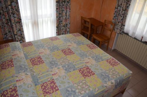uma colcha numa cama num quarto em Hotel Chateau des Dames em Breuil-Cervinia