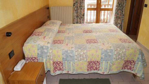 uma cama com uma colcha num quarto em Hotel Chateau des Dames em Breuil-Cervinia
