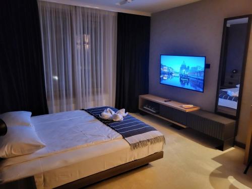 a bedroom with a bed and a flat screen tv at Woodside apartments Kopaonik in Kopaonik