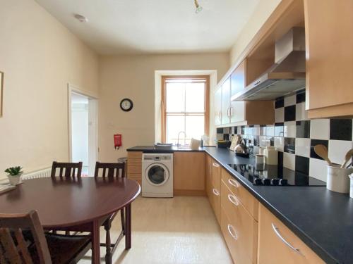 a kitchen with a table and a dining room at St John's Flat Spacious Accomodation in Dalry