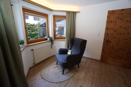 a living room with a chair and a window at Apart Lisa in Huben